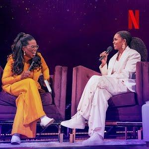 two women in suit sit in armchairs