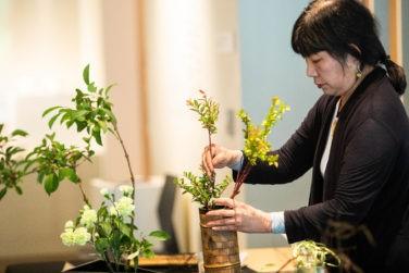 Woman creating an Ikebana floral arrangement.