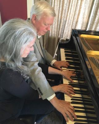 Two people playing piano duet