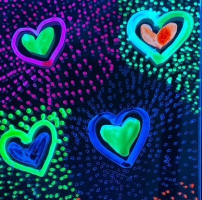 different color hearts illuminated on a dark background