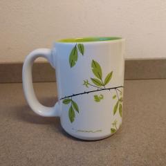 White mug with green leaves found in the Terrace Auditorium.