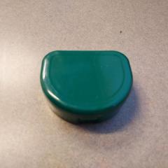 Green plastic retainer/denture container.