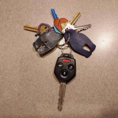 Set of keys with Subaru car key and multiple leather pieces attached.  Found in the Court elevator.