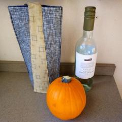 Soft sided wine bag with wine plus a paper bag with a pumpkin found in the North Pointe lobby.