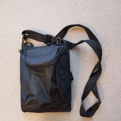 Small black travel purse with long strap left at Manor Reception.