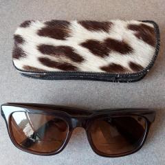 Bi-focal sunglasses and faux animal fur case found in the Terrace Auditorium.