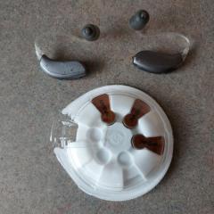 Set of hearing aids and a pack of batteries found in the Pantry.