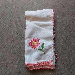 White handkerchief with pink flower embroidery found in the Manor.