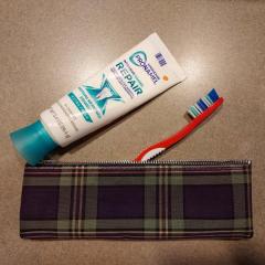 Plaid zipper bag with toothbrush and toothpaste.