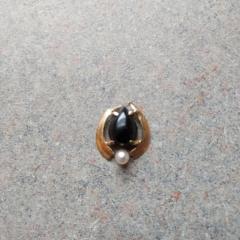 Small piece of jewelry: gold with a blue stone and a pearl.