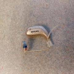 Hearing aid by Philips found in the gated lot by parking space E83.