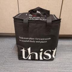 Black insulated shopping bag with flowers by Thistle found in front of the Manor.