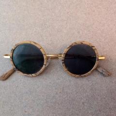 Round wood grain sunglasses found at doorway/entrance Manor garage & skybridge.
