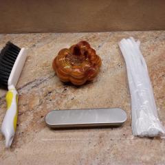 Glass pumpkin, hand broom, white pipe cleaners and silver box found in the Terrace library.