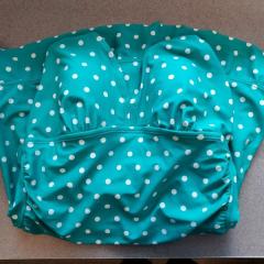 Womens one piece green swimsuit with white polka dots left at the pool.