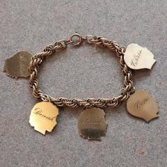 Gold charm bracelet with family names.