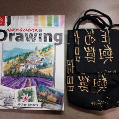 Purse (black with gold design) & Drawing Book found in a bag in the Manor Library.