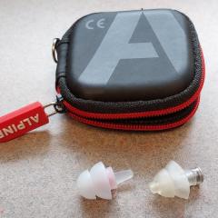 Black and red hearing aid case (Alpine) with hearing aids found in the Court entrance on a chair.