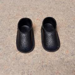 Black plastic doll shoes found in a Manor second floor laundry room washing machine.