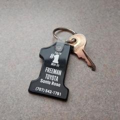 Silver key on black/white Freeman Toyota plastic #1 keychain.