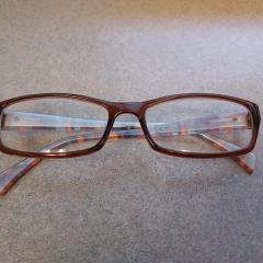 Womens brown reading glasses with colorful sides found in the Terrace driveway.
